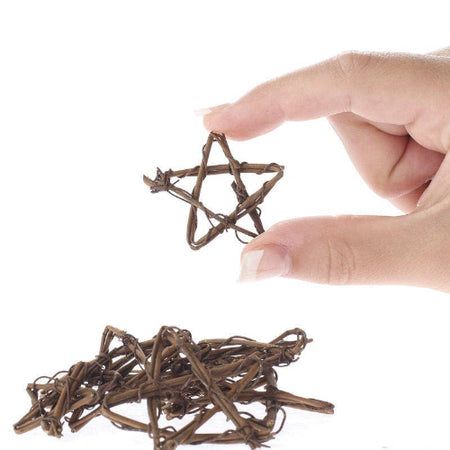 Hand holding a small twig star with more stars on a white background